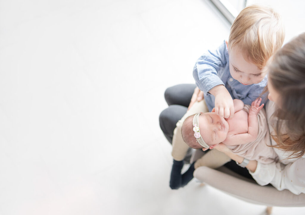 À Une maman et son fils Sur ses genoux en train de regarder leurs nouveaux nés qui vont arriver à la maison.